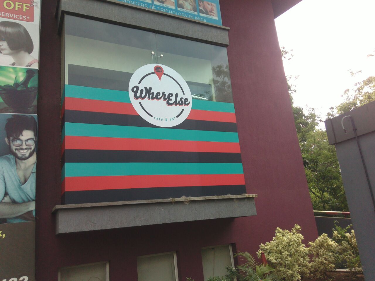 Huge logo of the Where Else Café printed on a film and pasted on the glass frontage of the building
