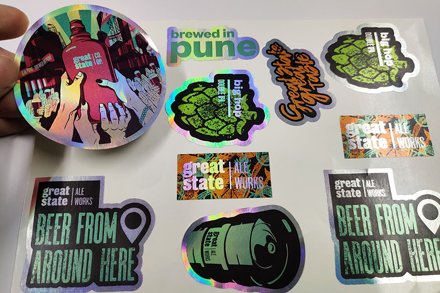 Silver stickers shaped cut with different designs, giving off a holographic rainbow effect
