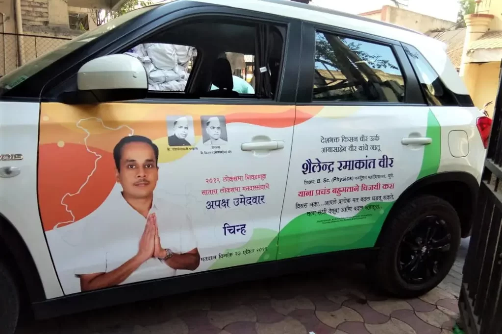 Colourful advertisement for a political candidate pasted on the side of a car using printed vehicle vinyl